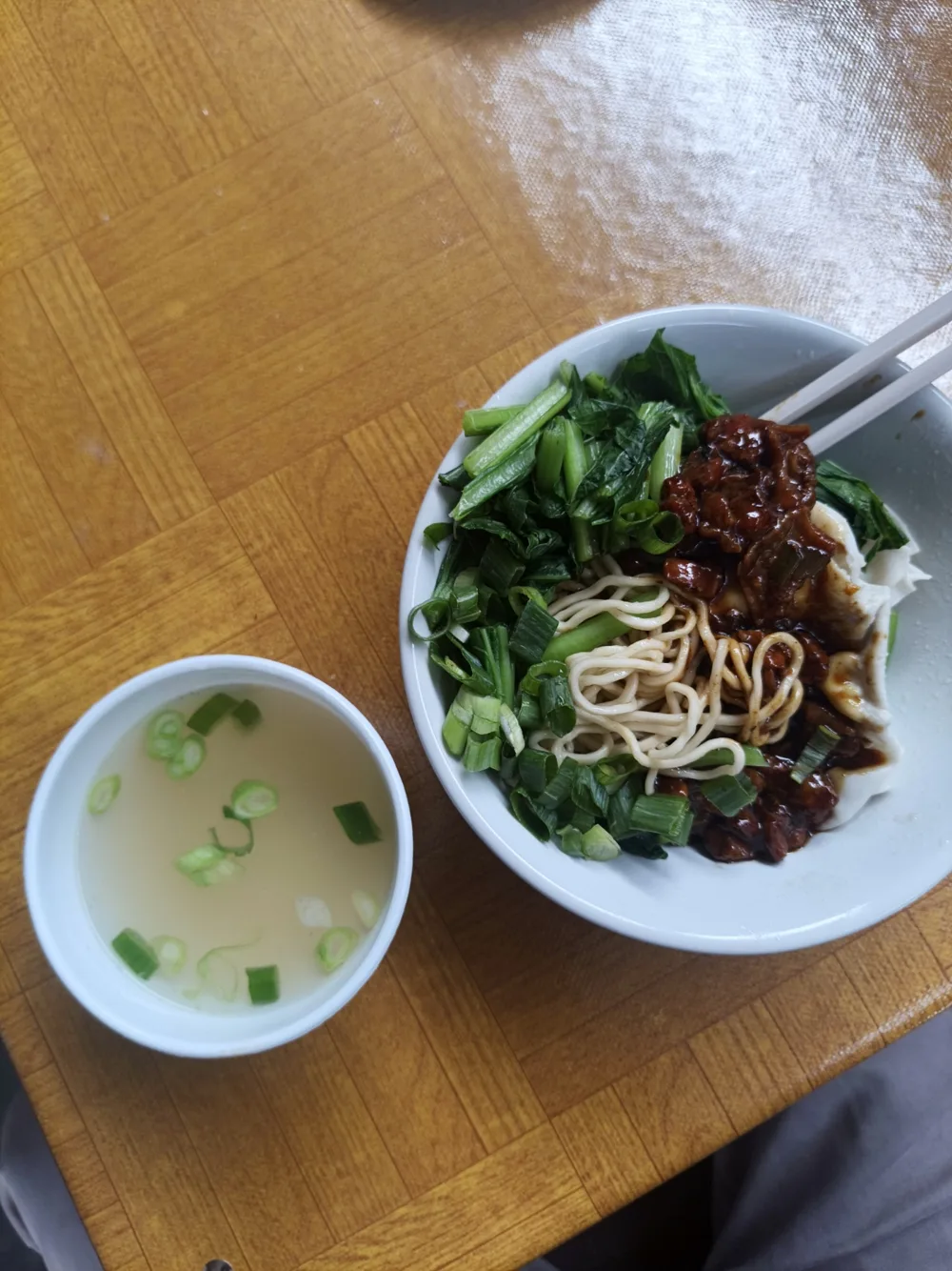 Bakmi dengan sayur hijau dan pangsit basah, disajikan bersama semangkuk kuah